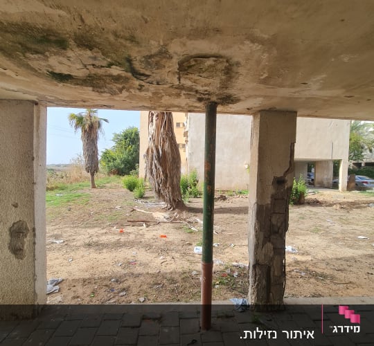 תקרה עם סימני רטיבות ותמיכה בעמוד מתכת